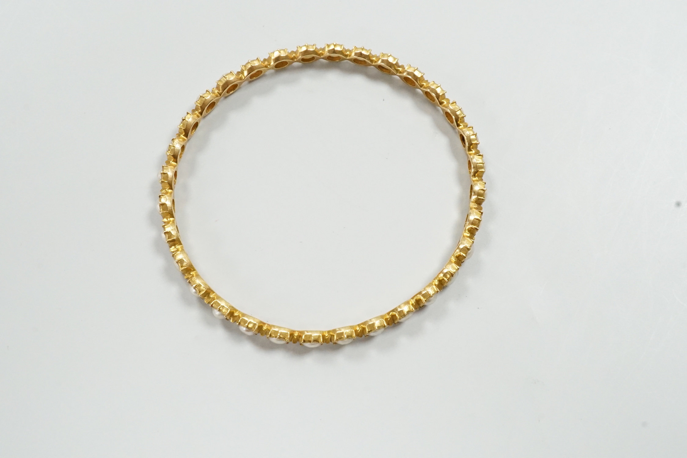 A modern yellow metal and split pearl set bangle, interior diameter approx. 58mm, gross weight 13.7 grams.